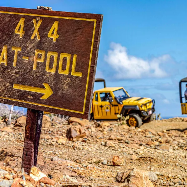 a truck that has a sign on a dirt road