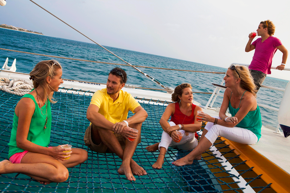 Group of friends enjoying a sunset sail in Aruba