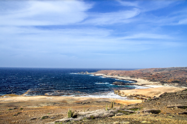 a sandy beach next to a body of water