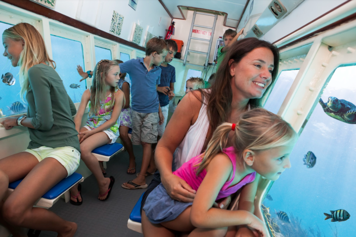 a group of young children sitting next to a woman