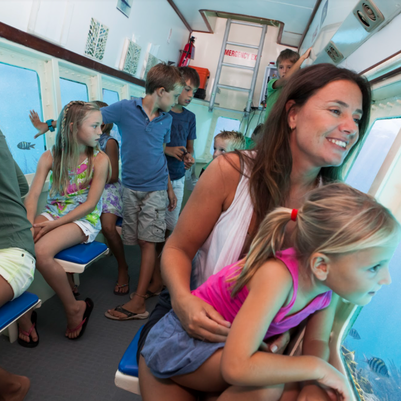 a group of young children sitting next to a woman