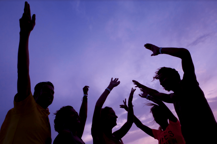 a group of people standing in front of a cloudy sky