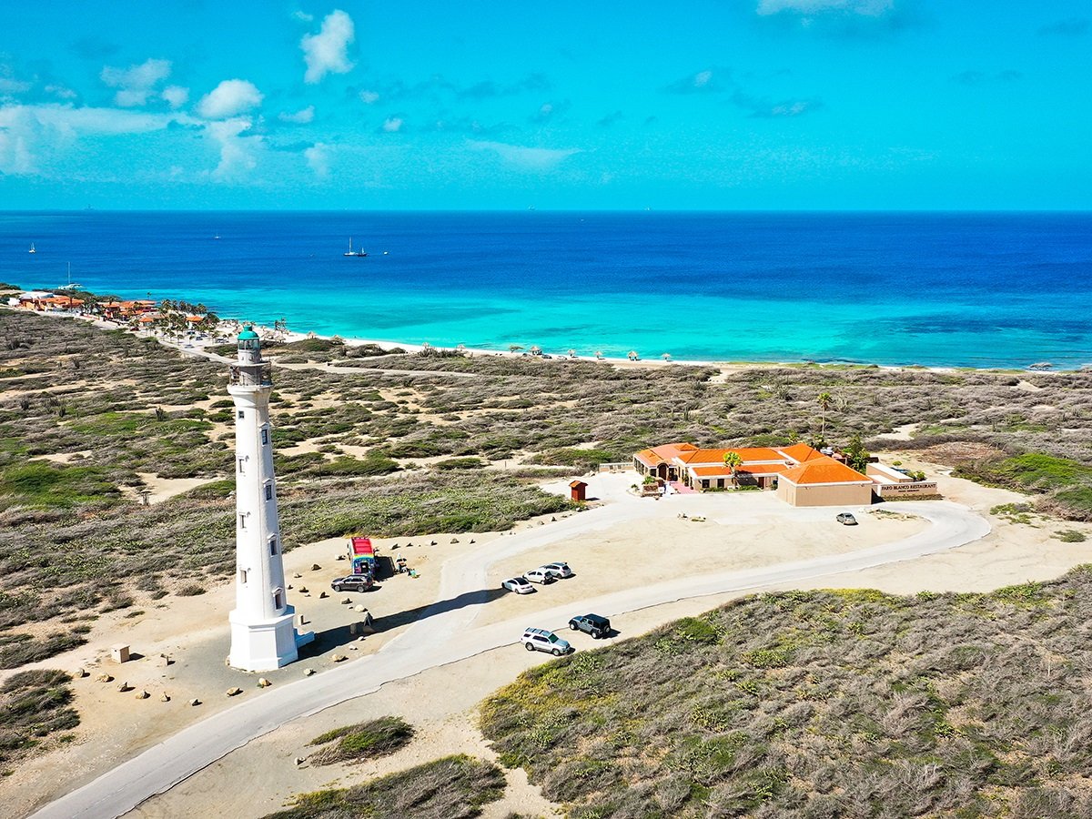 a group of lawn chairs sitting on top of a sandy beach