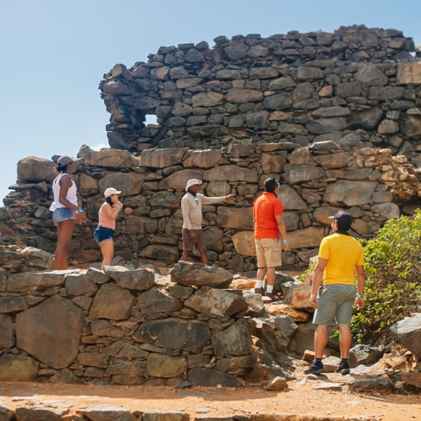 a man standing next to a stone wall