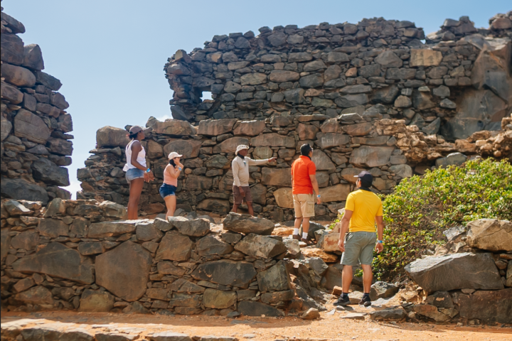 a man standing next to a stone wall