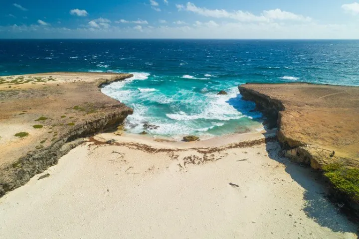 a sandy beach next to the ocean