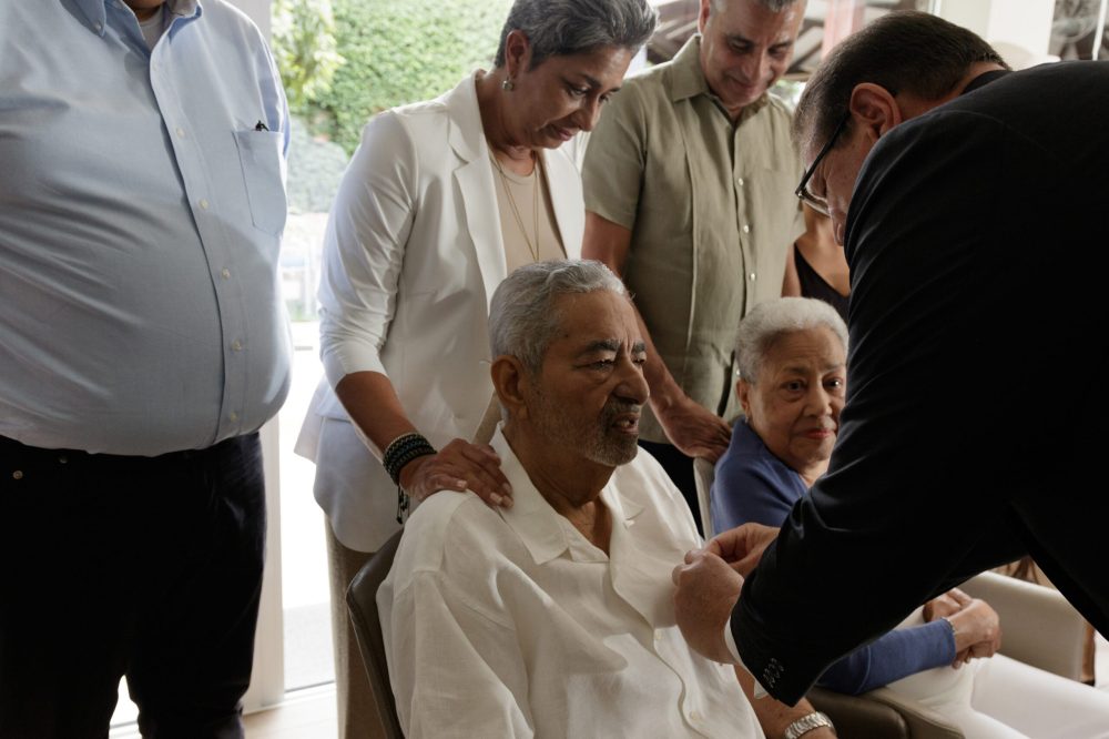 The governor of Aruba is bestowing Mr. Harold Malmberg with "Officer in de Orde van Oranje-Nassau"