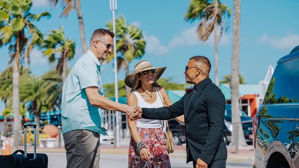 a man standing next to a palm tree