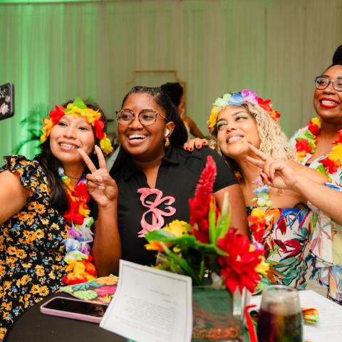 a group of people sitting at a table with a birthday cake