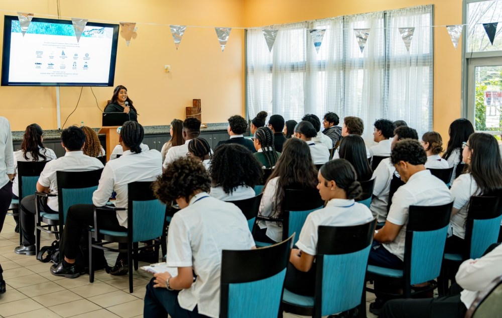 Teacher presenting to a classroom of students in uniforms.